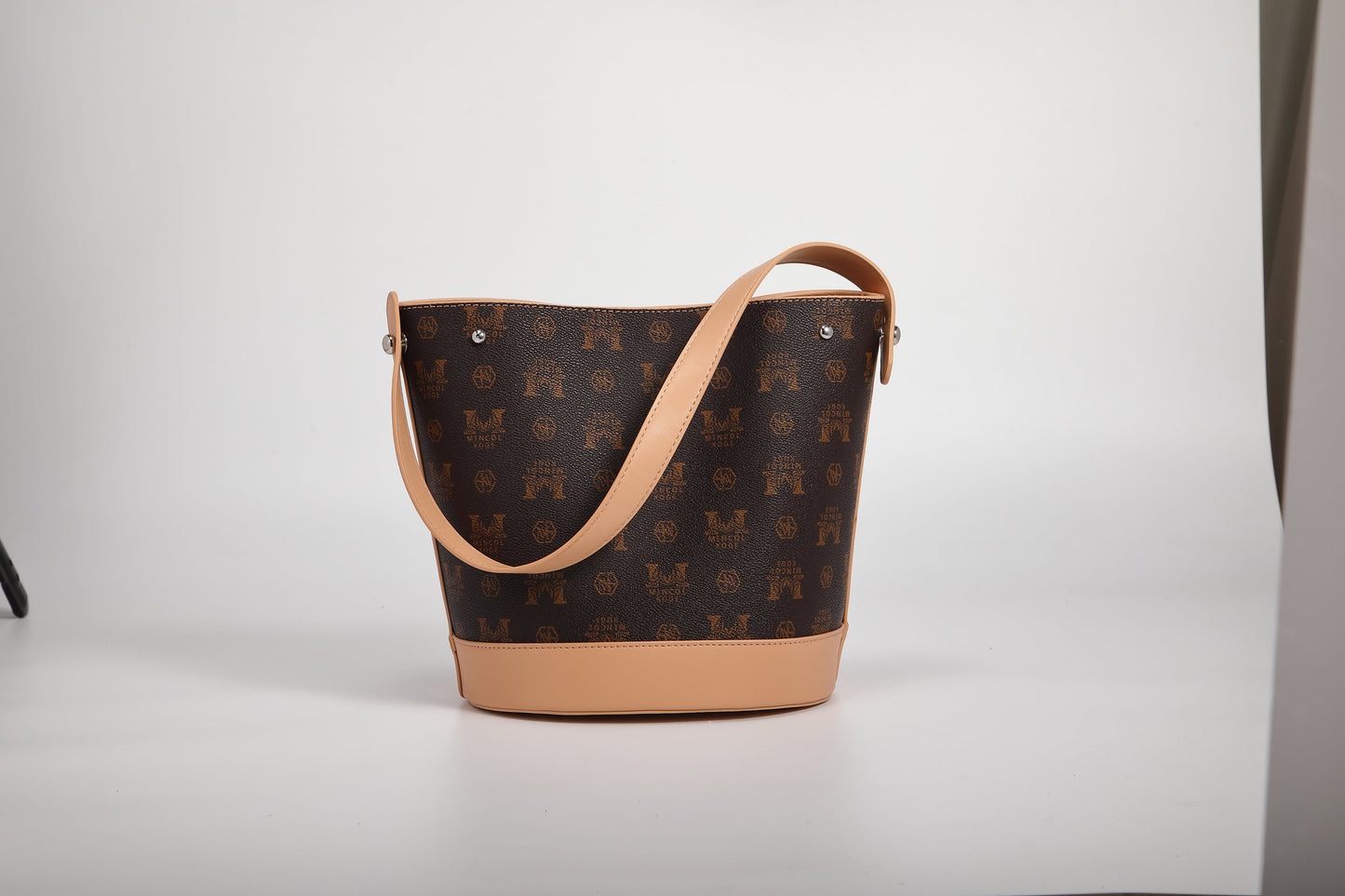 GESSY LOGO PRINT BUCKET BAG IN COFFEE