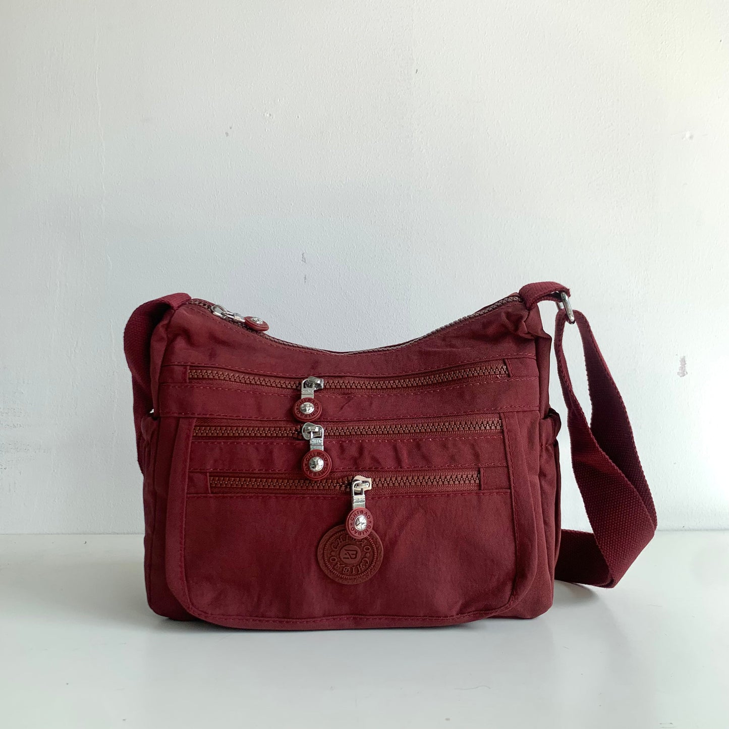 GESSY FRONT TRIPLE ZIP NYLON CROSSBODY BAG IN RED