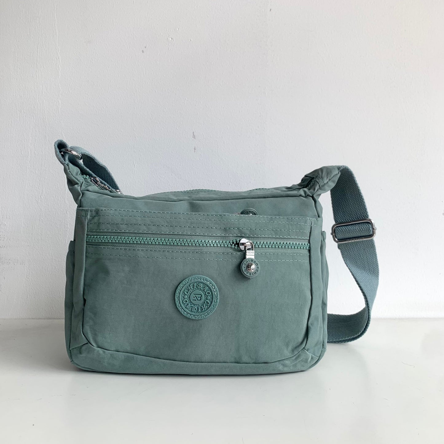 GESSY NYLON FRONT ZIP MULTI-LAYER CROSSBODY BAG IN GREEN